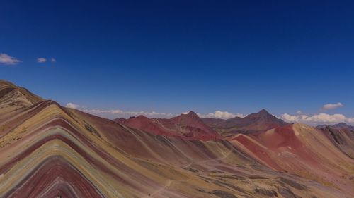 Scenic view of mountain range against blue sky