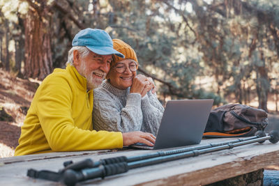 Side view of man using laptop while sitting in park