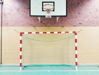 Low angle view of basketball hoop against wall in gym