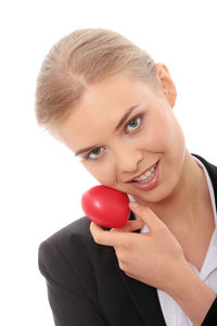 Close-up portrait of a smiling young woman over white background