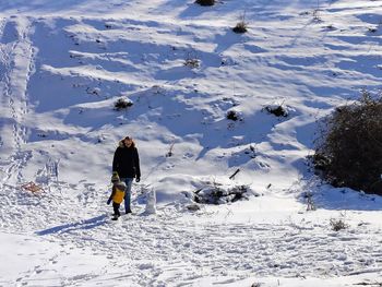 Full length of woman standing on snow covered land