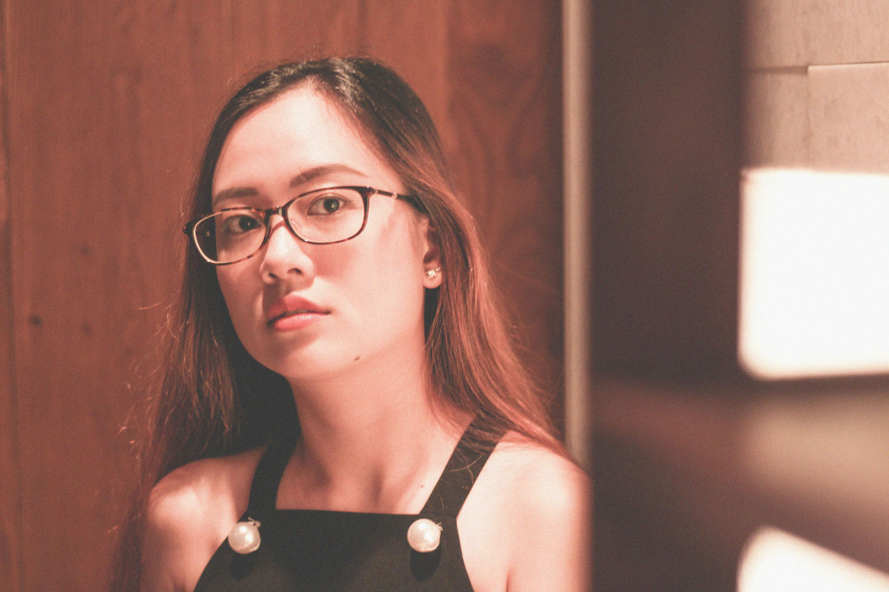 portrait, headshot, one person, eyeglasses, glasses, young adult, young women, real people, looking at camera, lifestyles, women, beauty, leisure activity, adult, front view, indoors, focus on foreground, beautiful woman, hairstyle, hair, contemplation