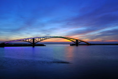 View of bridge over sea at sunset