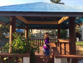 Side view portrait of woman standing in gazebo at park