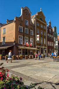 People on street against buildings in city