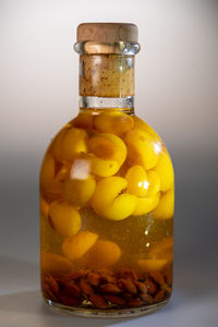 Close-up of lemon in glass container on table against wall