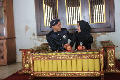 Newlywed couple sitting at temple