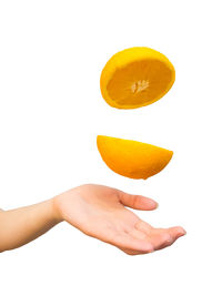 Close-up of hand holding apple against white background