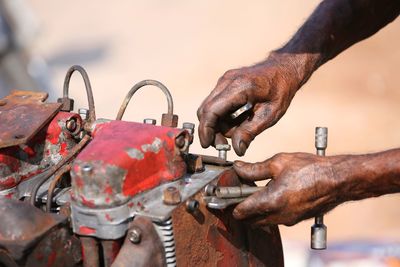 Close-up of man hands working on rusty machinery