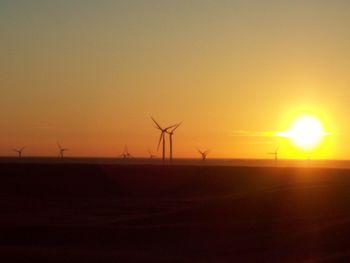 Silhouette of wind turbines at sunset