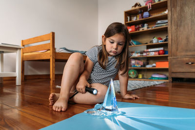 Portrait of young woman sitting on floor at home