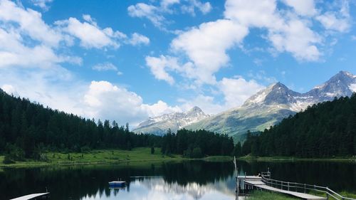 Scenic view of lake by mountains against sky