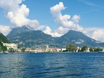 Scenic view of town by mountains against sky