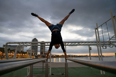 Low angle view of man jumping on bridge