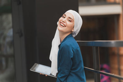 Portrait of young woman standing in city