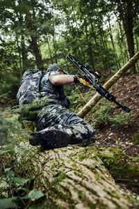 Man holding umbrella in forest