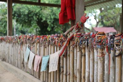 Prayer flags hanging against wooden fence