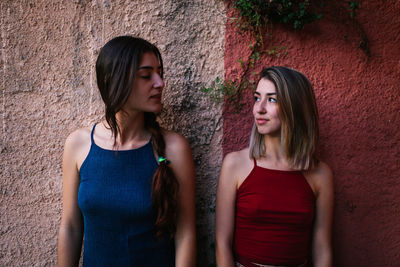 Portrait of a beautiful young woman against wall