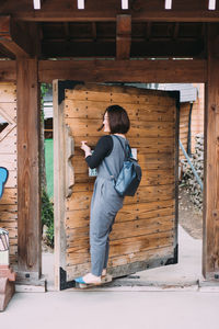 Rear view of man photographing woman standing in wood