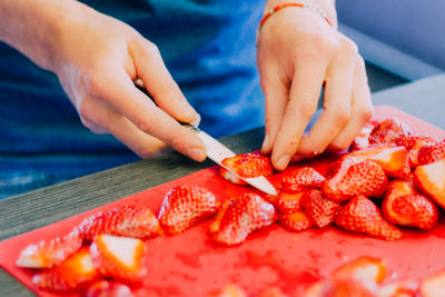 Close-up of hand slicing strawberries