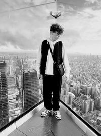 Portrait of young man standing against buildings