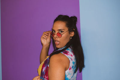 Portrait of woman against pink wall