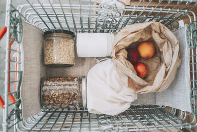 Mason jars and fruit bag in shopping basket at store
