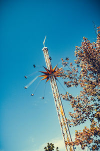Low angle view of flowering plant against blue sky