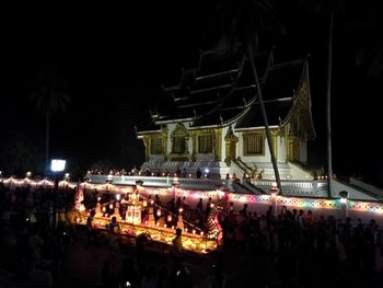 Crowd at concert against sky in city at night