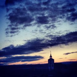 Built structure against cloudy sky at sunset