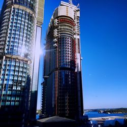Low angle view of modern buildings against clear blue sky