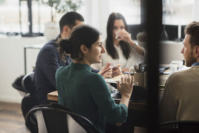 Businesswoman discussing with colleagues during meeting in office