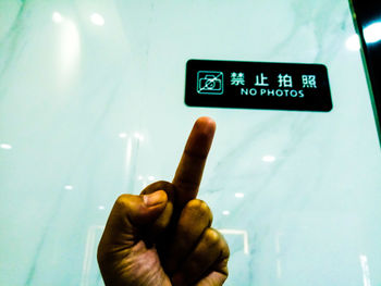 Person hand holding illuminated sign