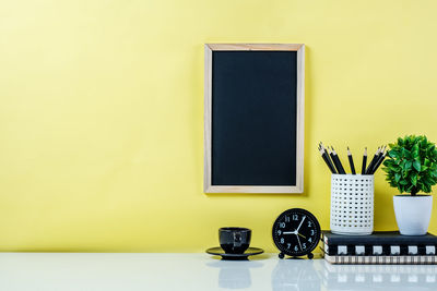 Close-up of yellow potted plant on table at home