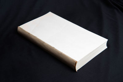 High angle view of open book on table against black background