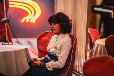 Woman looking away while sitting at restaurant