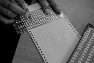 High angle view of person preparing braille book