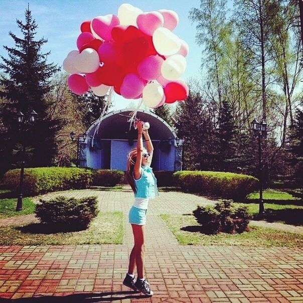 tree, flower, lifestyles, leisure activity, casual clothing, full length, park - man made space, standing, childhood, growth, girls, freshness, sunlight, holding, person, pink color, rear view, outdoors