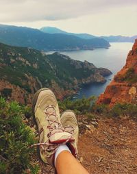 Low section of woman standing on cliff