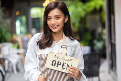 Portrait of young woman holding book