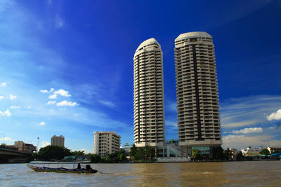 Skyscrapers in city against cloudy sky