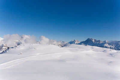 Scenic view of snowcapped mountains against clear blue sky