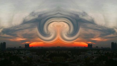 View of cityscape against cloudy sky at sunset