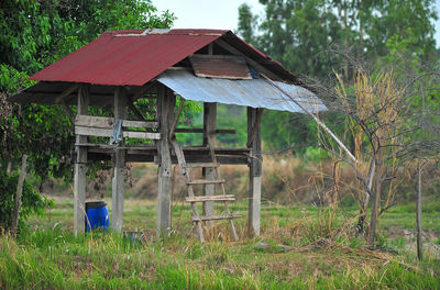 Abandoned house on field against trees