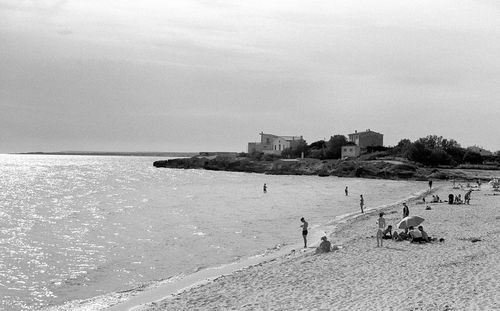 People on beach against sky