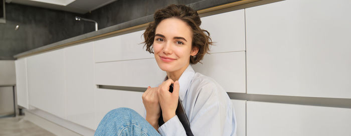 Portrait of young woman standing at home