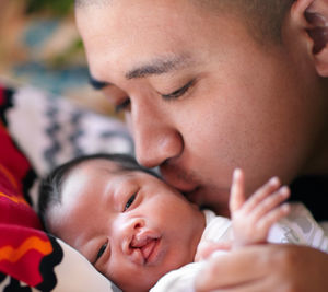 Father embracing daughter on bed