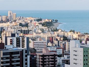 High angle view of buildings by sea against clear sky