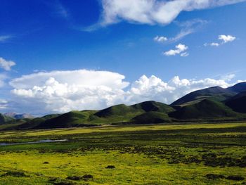 Scenic view of grassy field against cloudy sky