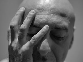 Close-up of man with hands covering eyes